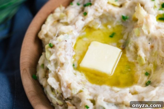 Velvety Leek and Cabbage Colcannon 2 A generous pat of rich Irish butter slowly melting into a warm, inviting bowl of Colcannon, creating a golden well of deliciousness.