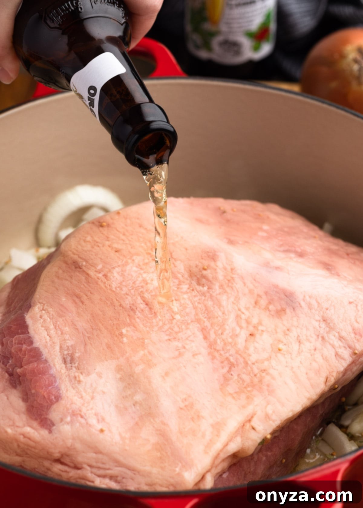 Golden Beer Braised Corned Beef Glazed with Whiskey Mustard 4 Pouring beer over a corned beef brisket in an enameled cast iron Dutch oven