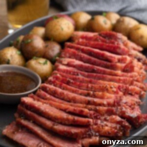 Golden Beer Braised Corned Beef Glazed with Whiskey Mustard 9 Sliced beer braised corned beef with whiskey mustard glaze on a gray ceramic platter with baby potatoes
