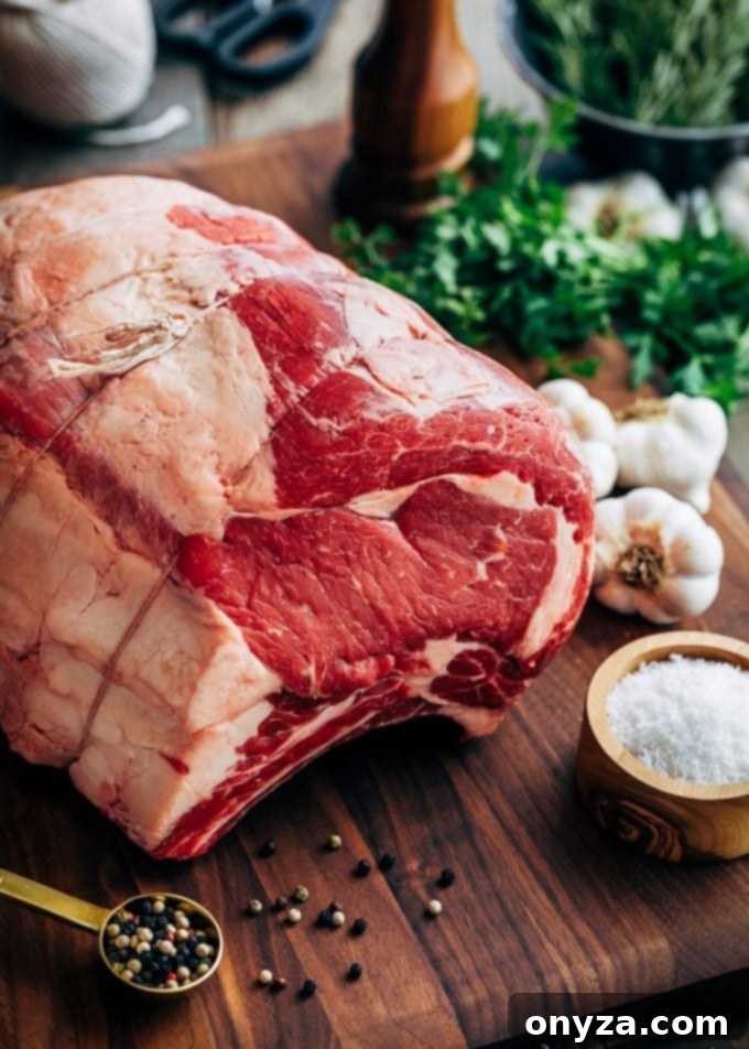 Uncooked prime rib seasoned with herbs and garlic, ready for preparation.