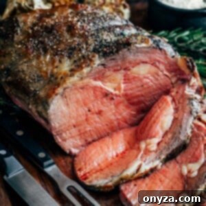 partially sliced slow roasted prime rib on a carving board