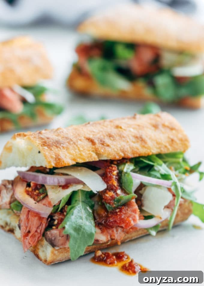 Gourmet Roast Beef Sandwiches with Sun-Dried Tomato Pesto 4 Prime rib sandwich with pesto rosso, shaved asiago, and arugula on a ciabatta roll, ready to serve and enjoy