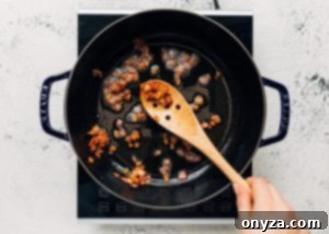 Crisped bacon sizzling in a Staub cast iron pot, removed and set aside for later.