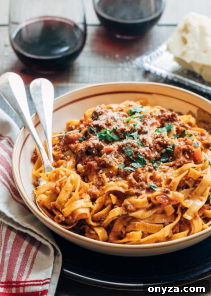Ultimate Instant Pot Bolognese 2 Bolognese sauce recipe served with tagliatelle in a bowl, garnished with Parmesan cheese and parsley