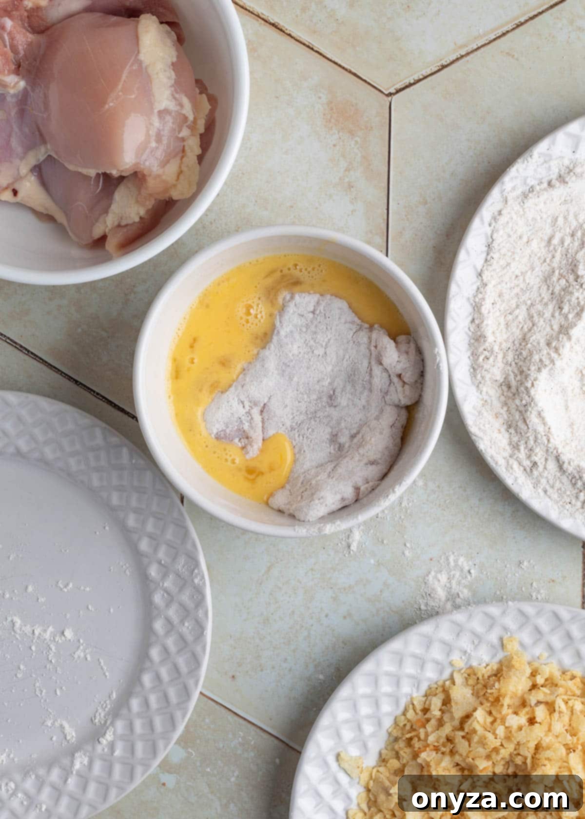 Dipping chicken into egg wash