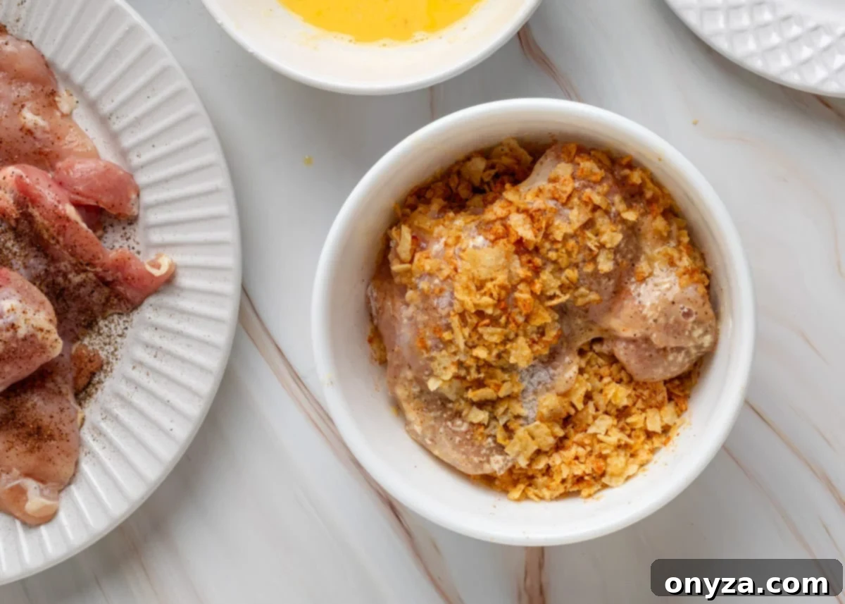 Coating chicken in crushed potato chips.